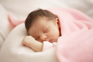 Close up of infant sleeping in blanket